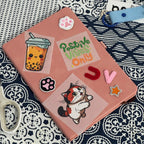 Close-up of a personalized pink A5 notebook decorated with custom stickers and patches including a boba tea, a cat, and "Positive Vibes Only" text.
