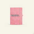 Pink notebook with 'HAZEL' embroidery patches on it against a white background.