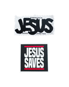 Two rectangular patches with religious text on a white background: the top patch reads 'STRENGTH IN JESUS SAVES LOVES YOU' in black lettering on a white patch, and the bottom patch reads 'JESUS SAVES' in white block letters on a black patch with red horizontal lines.