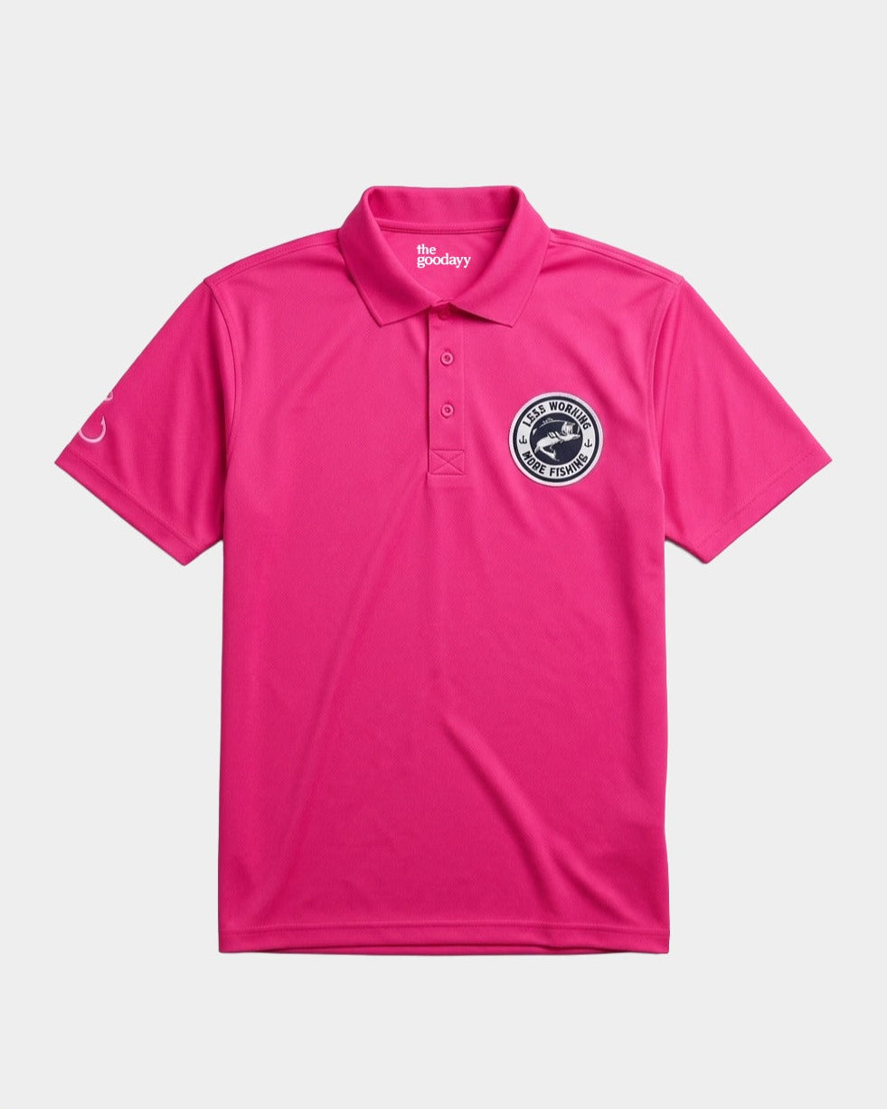 A bright pink polo shirt with a three-button placket, featuring a circular black and white logo on the left chest and a small white logo on the right sleeve, displayed on a light gray background.