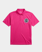 A bright pink polo shirt with a three-button placket, featuring a circular black and white logo on the left chest and a small white logo on the right sleeve, displayed on a light gray background.