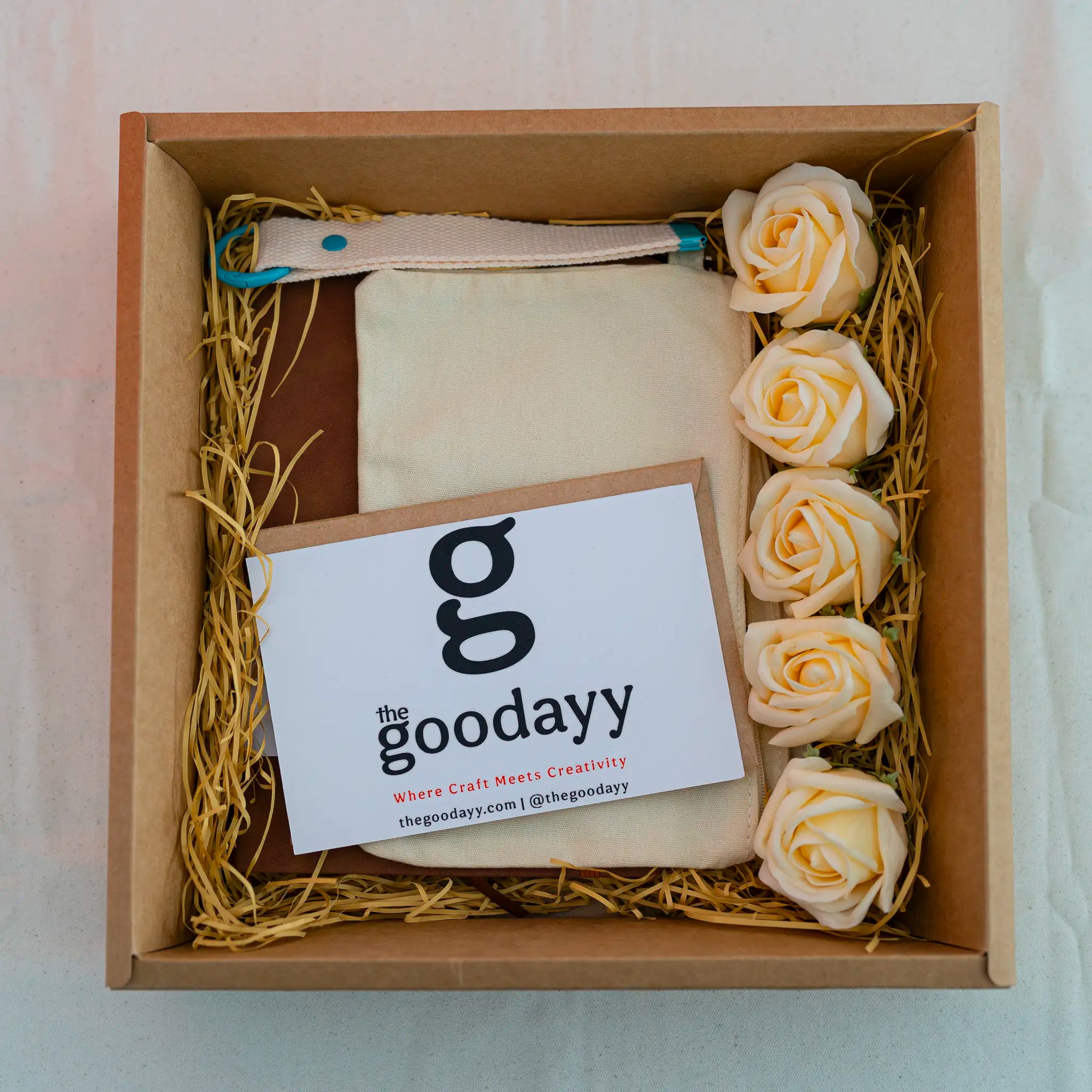 The Fivefold Affection cream personalized gift box set featuring triple custom printing on a canvas pouch, A5 notebook, and keychain strap, accented with five cream soap roses and a red gingham ribbon.