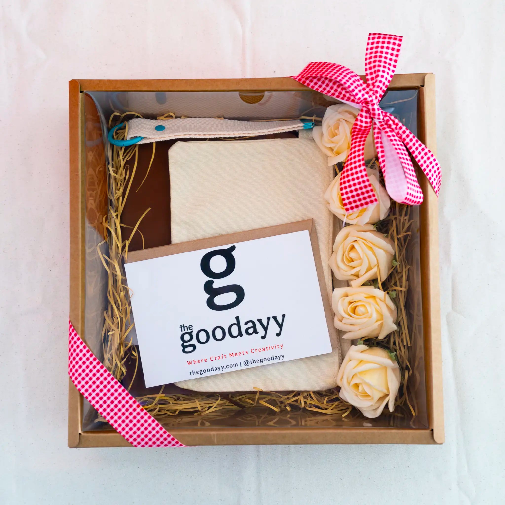 The Fivefold Affection cream personalized gift box set featuring triple custom printing on a canvas pouch, A5 notebook, and keychain strap, accented with five cream soap roses and a red gingham ribbon.