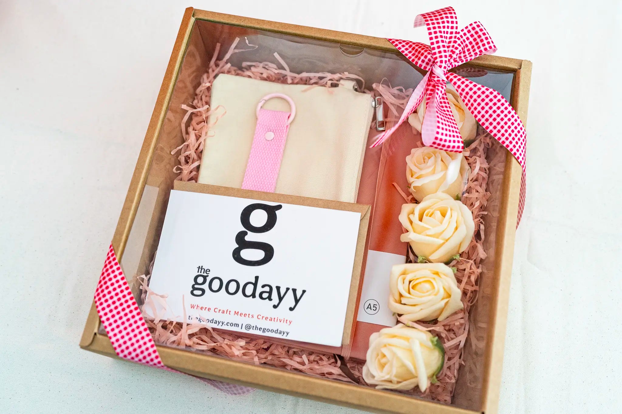 Personalized pink gift box bundle from The Fivefold Affection series with matching name printing on a dusty rose notebook, pouch, and strap tag, nestled in pink shredded paper with soap roses.