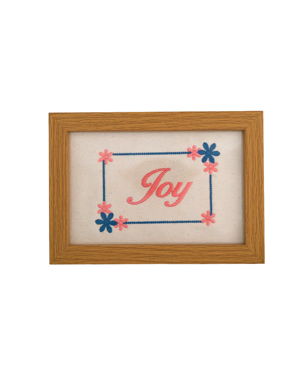 Medium-toned wood frame with pink script reading "Joy" surrounded by an embroidered blue and pink floral border.