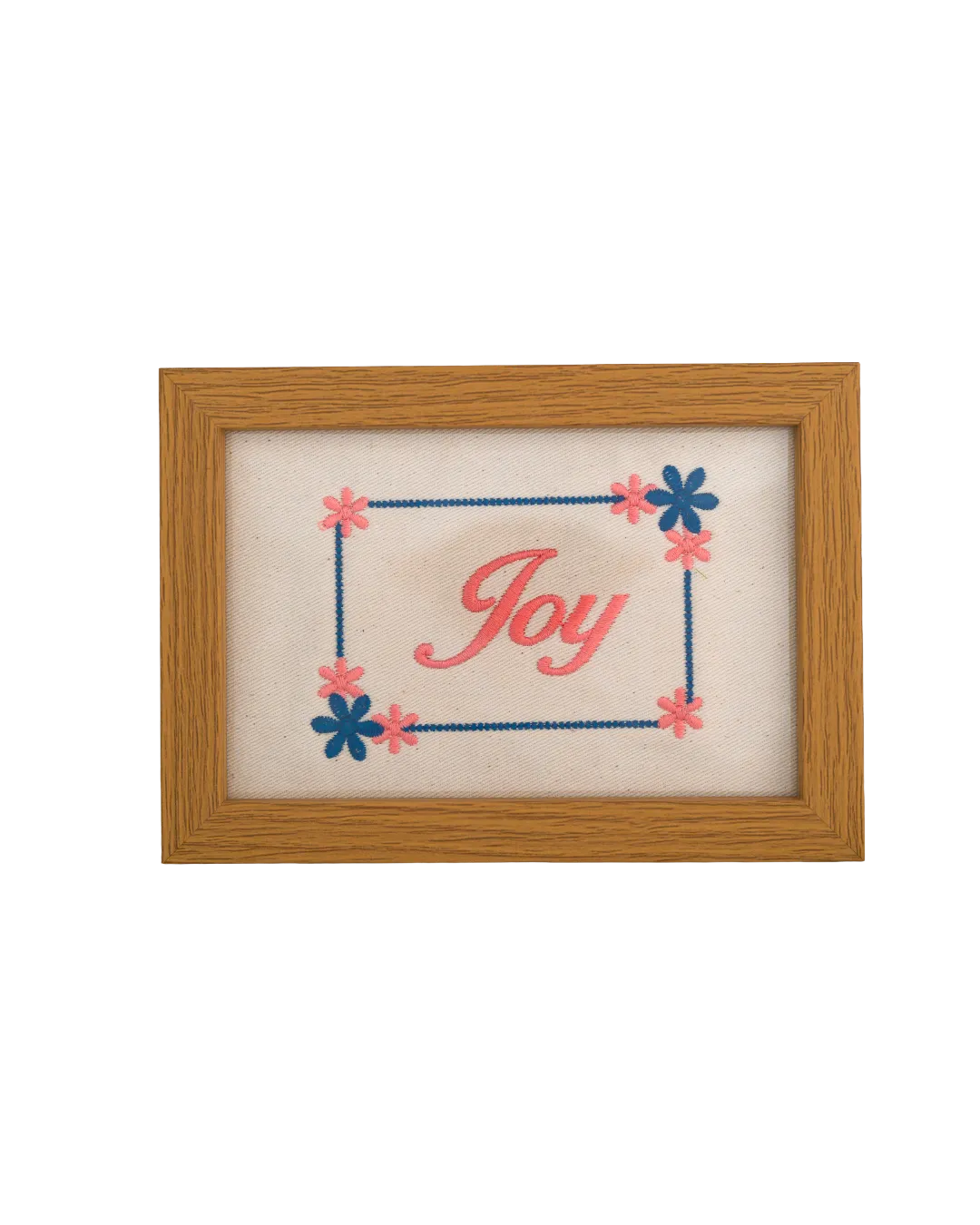 Medium-toned wood frame with pink script reading "Joy" surrounded by an embroidered blue and pink floral border.