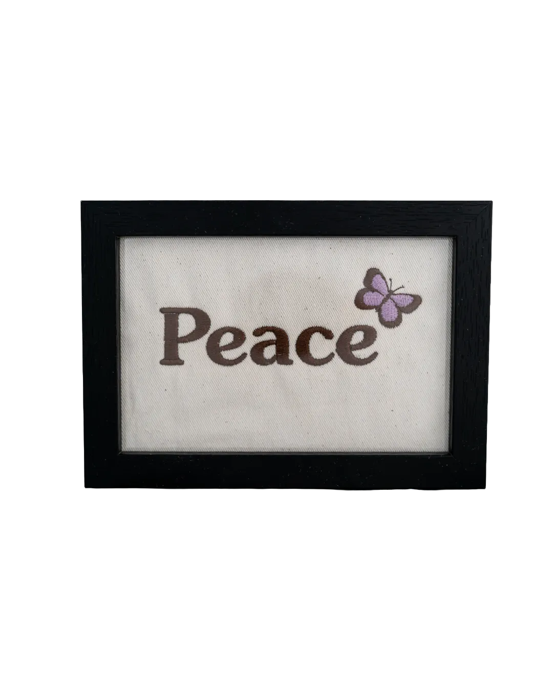 Black wood frame featuring the word "Peace" embroidered in dark thread with a purple butterfly on cream canvas.