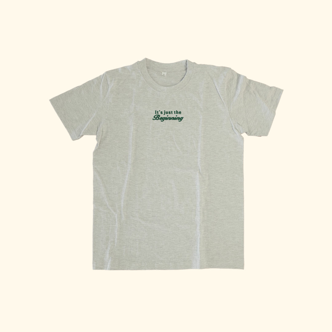 Image of model wearing  "its just the beginning" embroidered on a 200gsm cotton tee that is available in 3 colours and available in 4 sizes, S M L XL and 2XL.