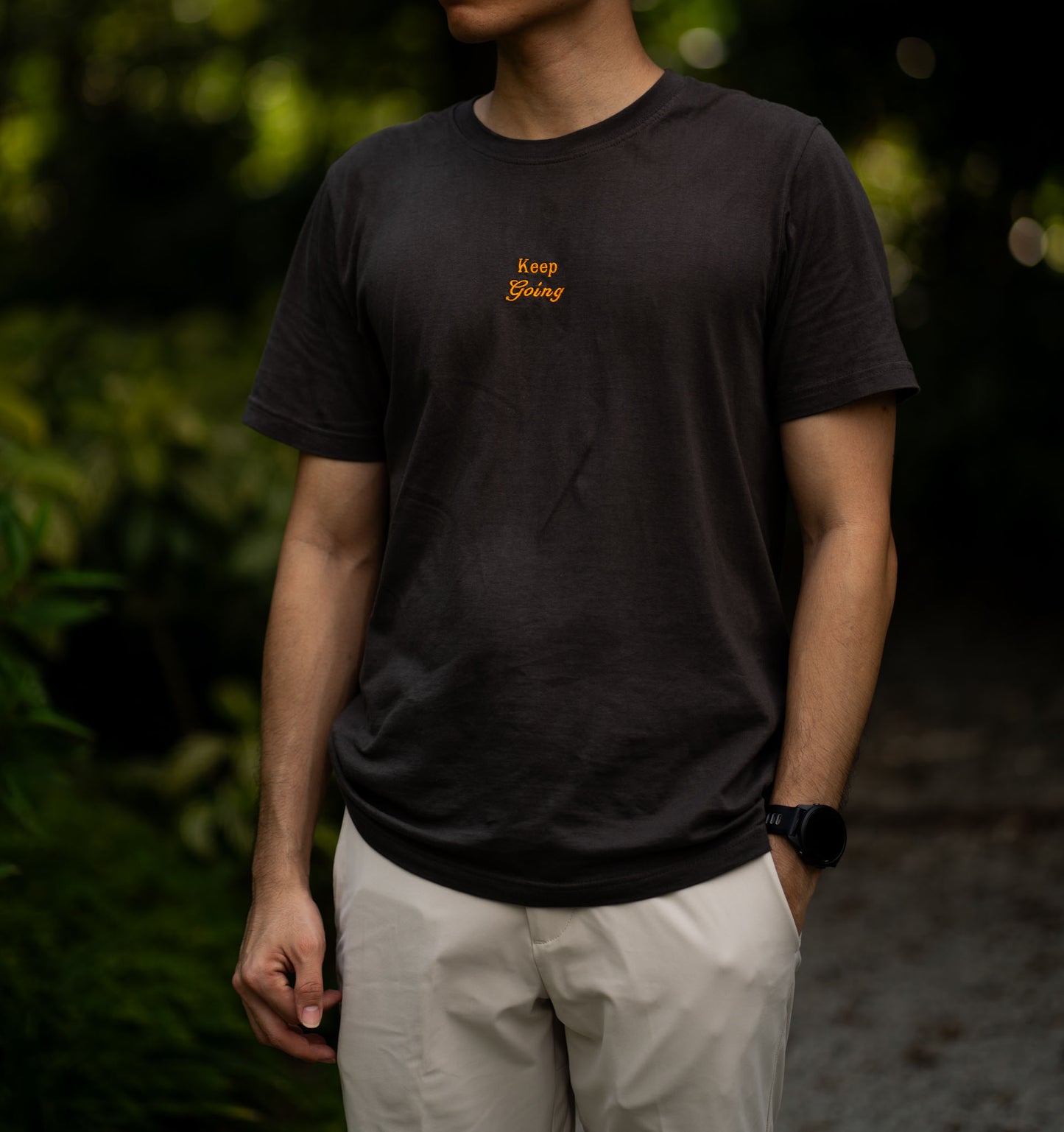 Image of model wearing  "keep going" embroidered on a 200gsm cotton tee that is available in 3 colours and available in 4 sizes, S M L XL and 2XL.