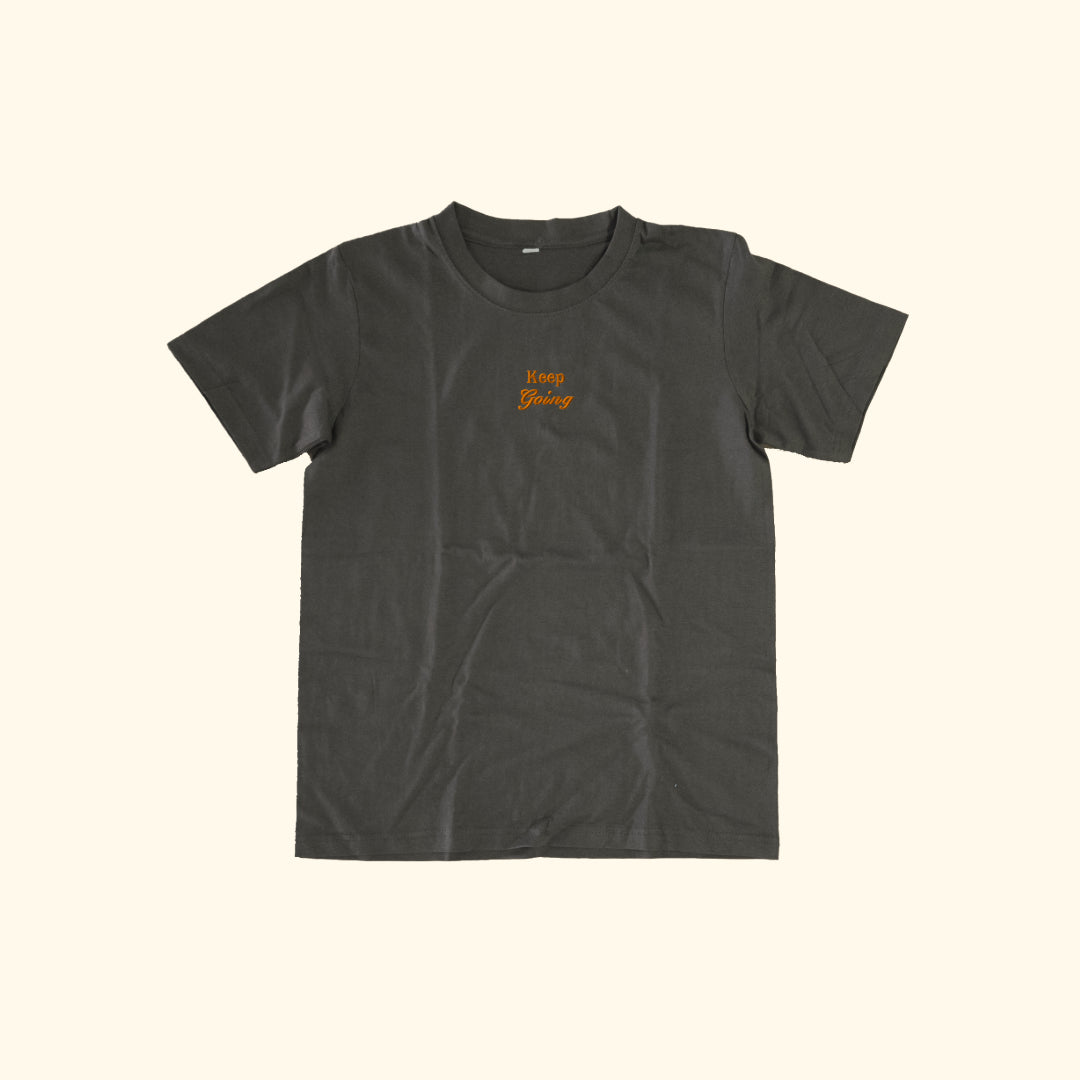 Image of model wearing  "keep going" embroidered on a 200gsm cotton tee that is available in 3 colours and available in 4 sizes, S M L XL and 2XL.