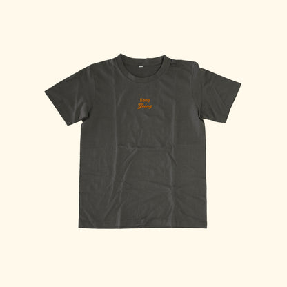 Image of model wearing  "keep going" embroidered on a 200gsm cotton tee that is available in 3 colours and available in 4 sizes, S M L XL and 2XL.