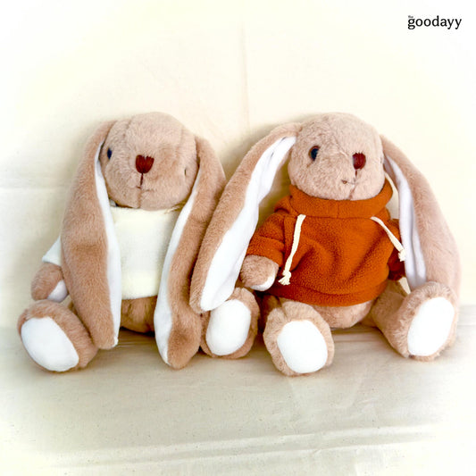 Two brown plush bunny soft toys with long white ears, one wearing a white shirt and the other wearing an orange hoodie, customizable with embroidery on the ear
